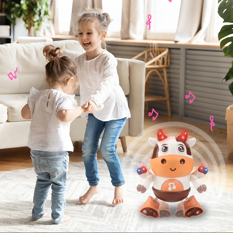 Vaikai šoka šviesiame kambaryje su žaisliniu rudu ir baltu karvės formos robotu.