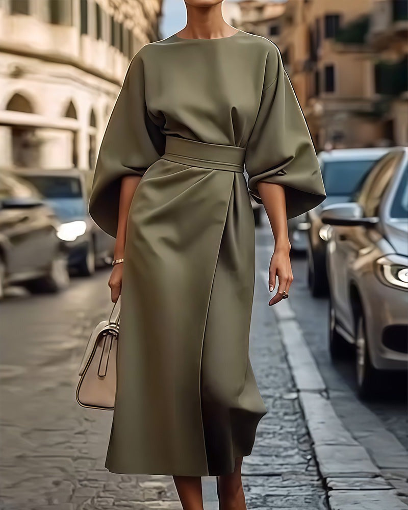 Žalia suknelė, ilgos rankovės, lygus audinys, elegantiškas dizainas, miesto gatvė.