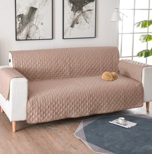 Rudos spalvos, kvadratinio rašto sofa, su švelnia tekstūra ir medinėmis kojelėmis.