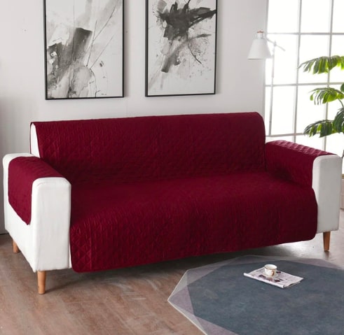 Raudonas, kvadratinis sofa užvalkalas su baltomis rankovėmis ir medinėmis kojelėmis.