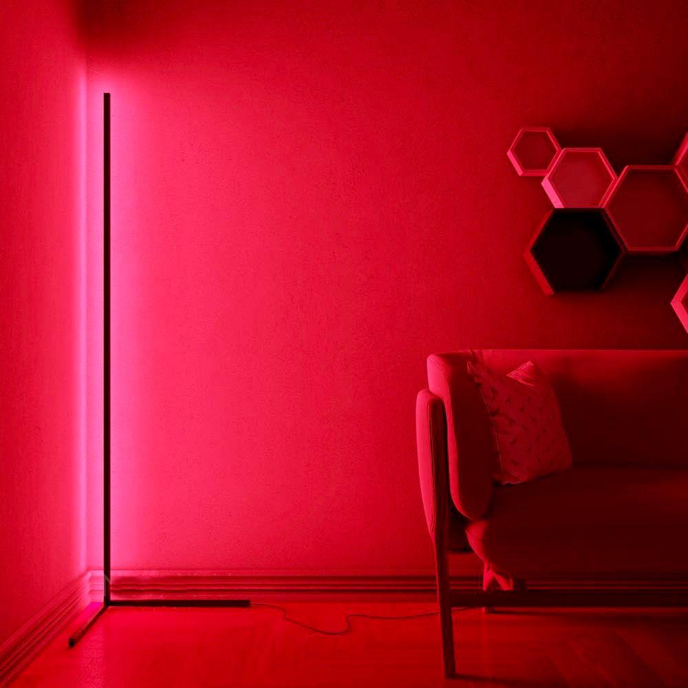 Raudonas kambarys su juoda lempa, šešiakampės lentynos, rožinė sofa.