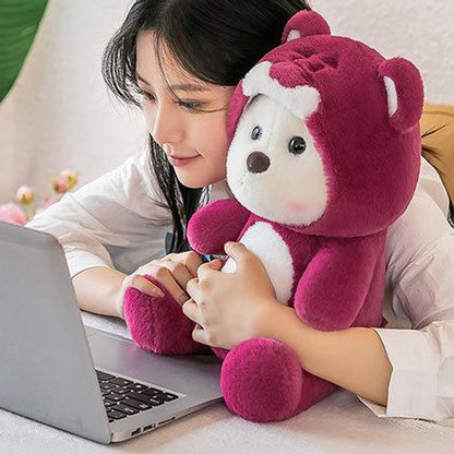 Moteris prie nešiojamojo kompiuterio apkabinusi bordo meškiną