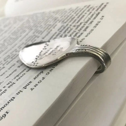 Lenkto metalinio skirtuko vaizdas iš šono ant knygos