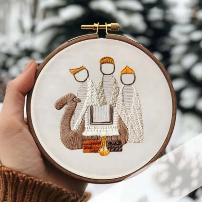 Trijų piemenų siuvinėjimas laikomas rankoje