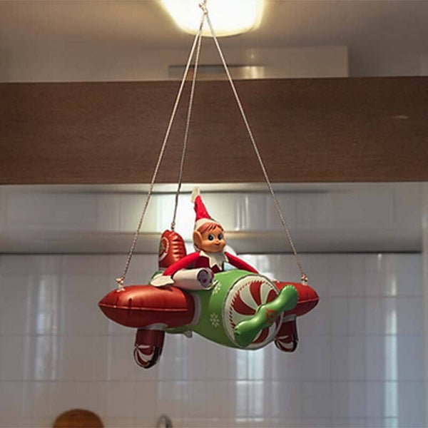 Žaislinis elfas pakabintas žaisliniame lėktuve