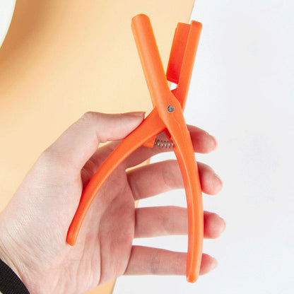 Oranžinės krevečių replės laikomos rankoje