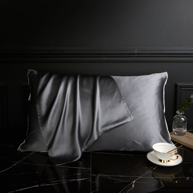 Juodas satino pagalvės užvalkalas su švelniu blizgesiu ir minkšta tekstūra.