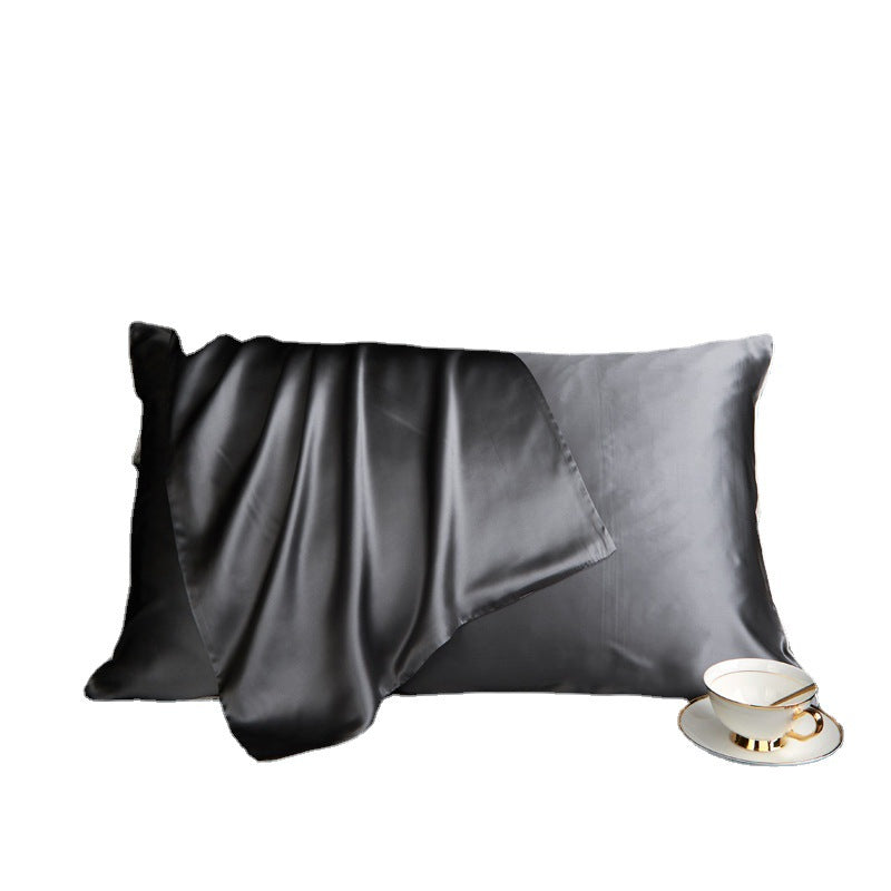 Juodas satino pagalvės užvalkalas su švelniu blizgesiu ir elegantiška puodelio pora.
