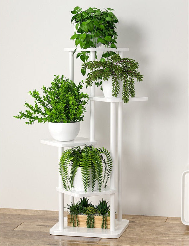 Balta gėlių lentyna su žaliais augalais, moderni, minimalistinė, su lygiomis linijomis.