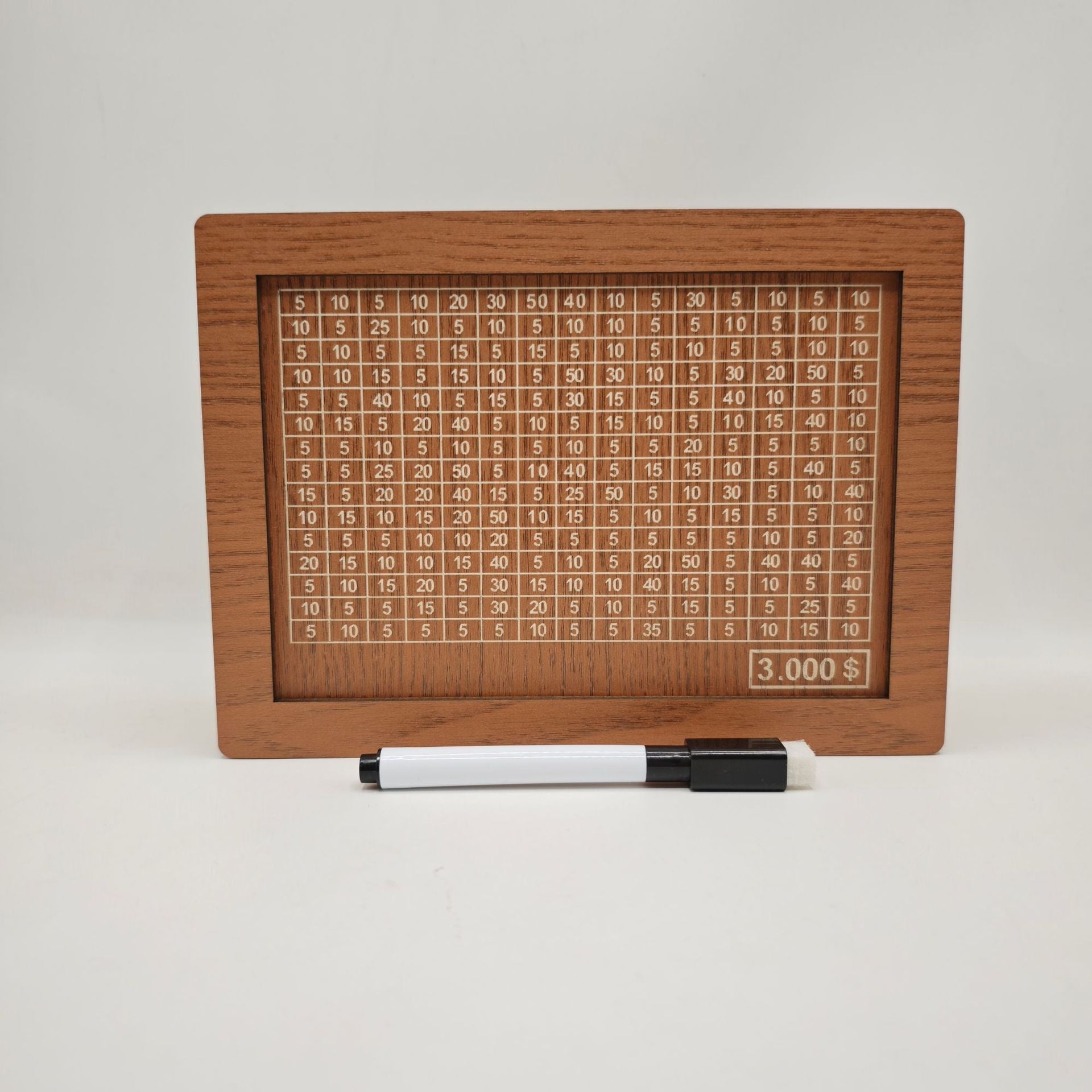 Medinis skaičiavimo lentelė su baltais skaičiais, šalia juodas rašiklis.