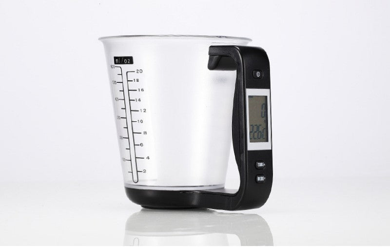 Skaitmeninis matavimo puodelis, skaidrus, su juodu rankena ir ekranėliu.