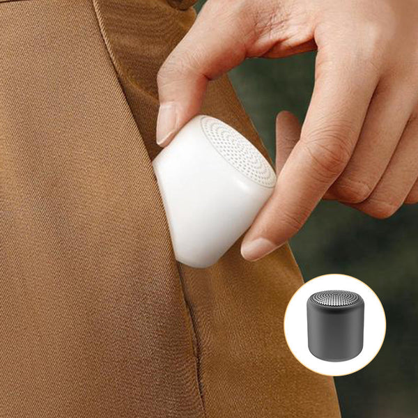 Balta mini Bluetooth kolonėlė įdedama į kelnių kišenę