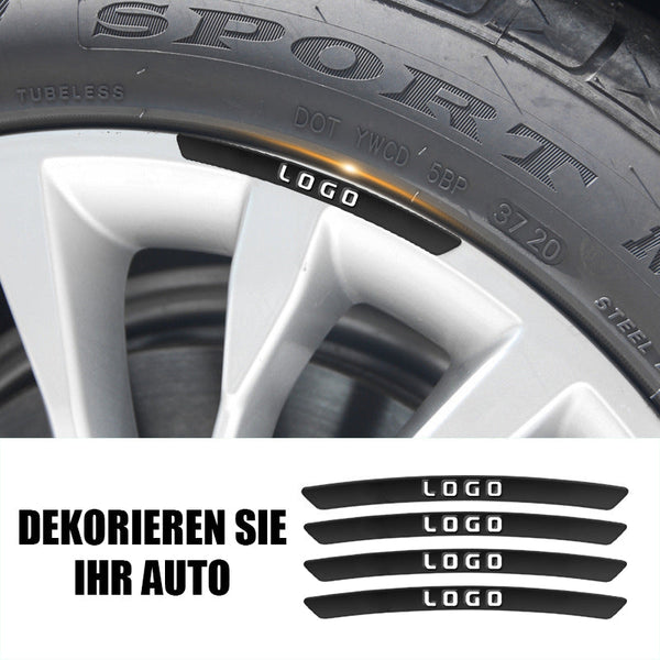 Keturi sidabriniai dekoratyviniai lipdukai priklijuoti prie automobilio ratlankio.