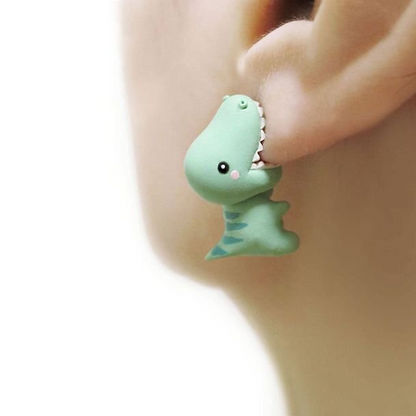 Žalias dinozauro formos auskaras ausyje iš arti