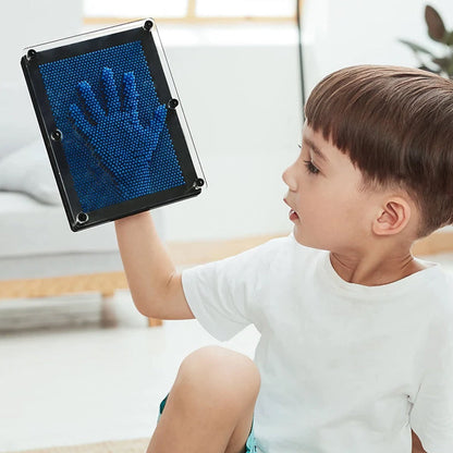 Berniukas laiko mėlyną 3D smeigtukų lentą su rankos atspaudu