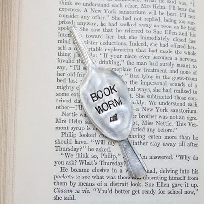 Book worm šaukšto formos skirtukas knygos puslapyje