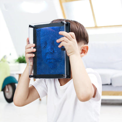 Berniukas prispaudžia veidą prie mėlynos 3D smeigtukų lentos