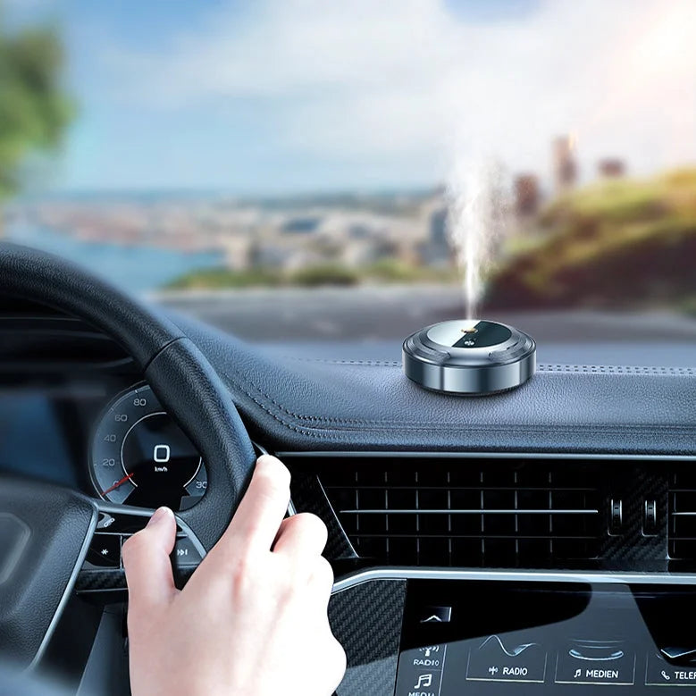 Apvalus sidabrinis difuzorius ant automobilio prietaisų skydelio, skleidžiantis garus.