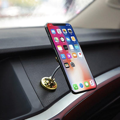 Aukso spalvos laikiklyje pritvirtintas telefonas ant automobilio panelės