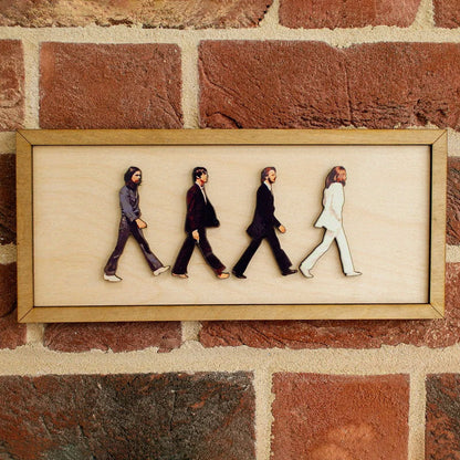 The Beatles medinis paveikslas ant plytų sienos