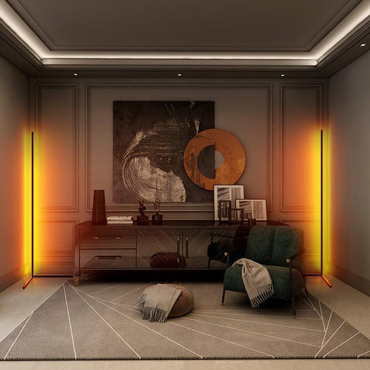 A modern living room with orange lights, abstract art, and a green chair.