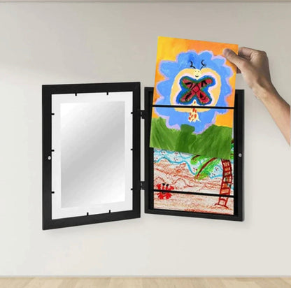 Ranka į atvertą juodą rėmelį deda piešinį su drugeliu