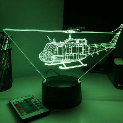 Žalias 3D sraigtasparnio modelis ant juodo pagrindo, šviečiantis tamsiame kambaryje.