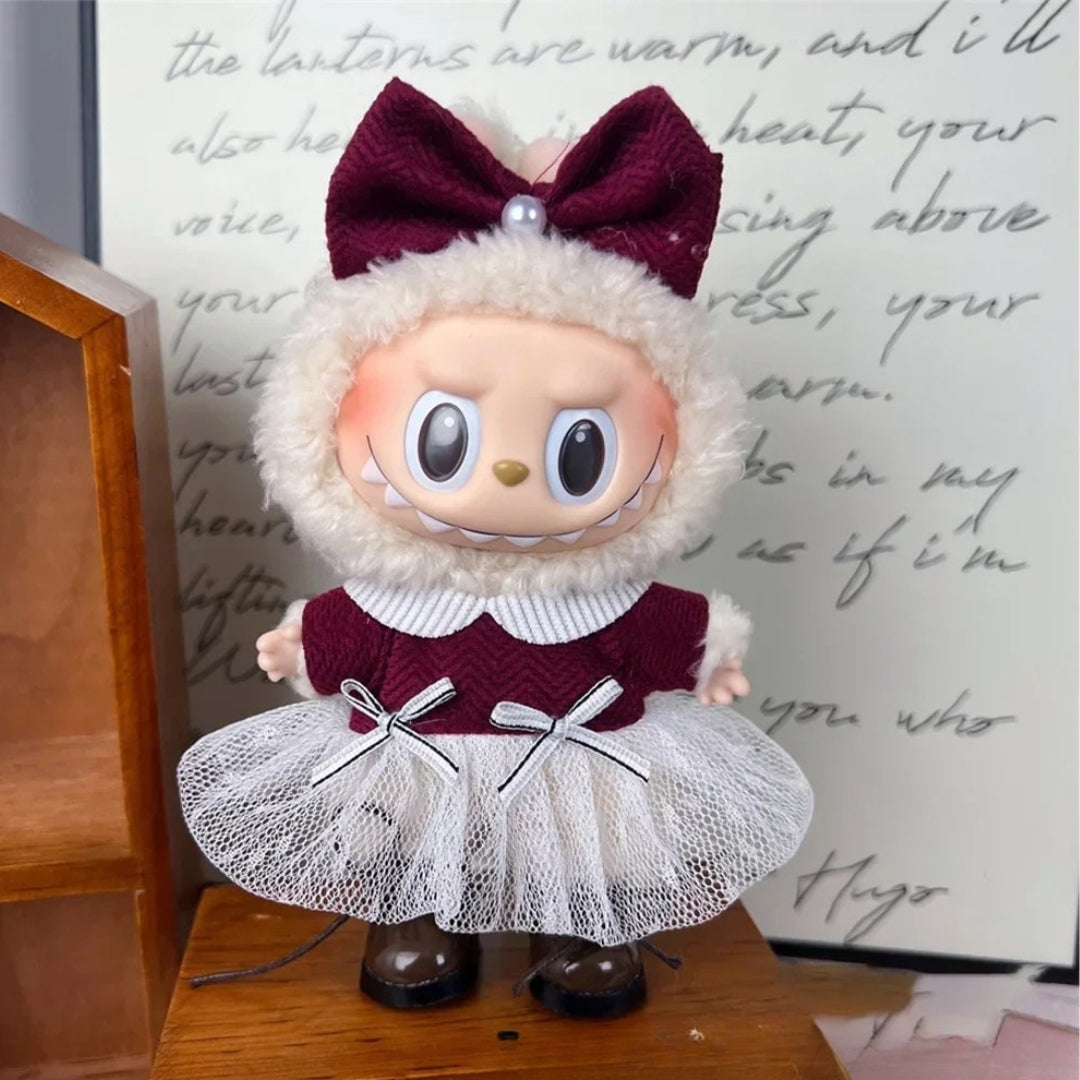 Labubu lėlė, apvalus veidas, rausvas, vilnonis baltas gaubtas, tinklelio balta suknelė