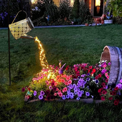 LED girliandos teka iš laistytuvo virš gėlių