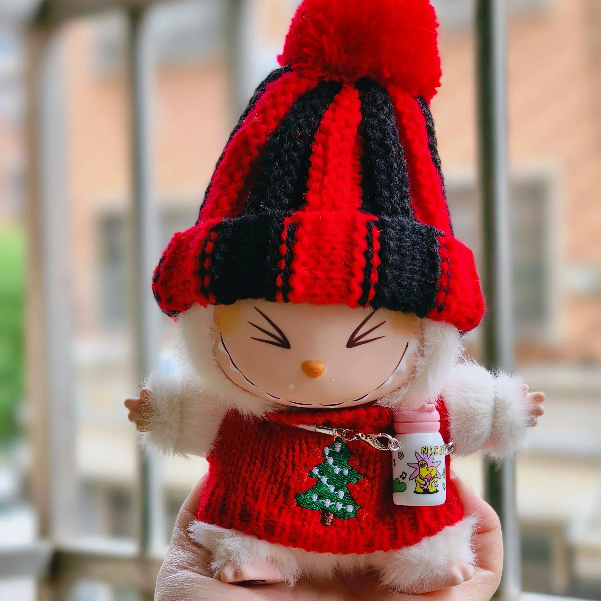 Apvalios formos raudona ir juoda megzta kepurė, pūkuota balta Labubu lėlė