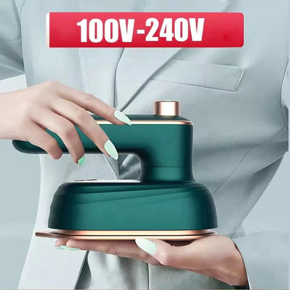 Ranka laiko žalią drabužių garintuvą, šalia nurodyta 100–240 V įtampa