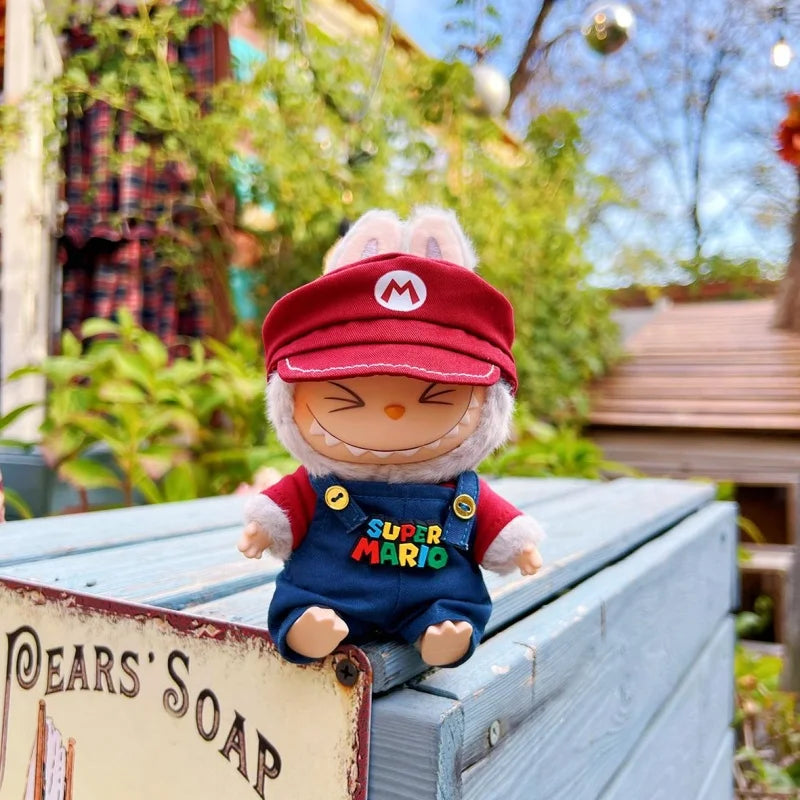 Apvali pūkuota Labubu lėlė su raudona kepure, mėlynu medvilniniu kombinezonu