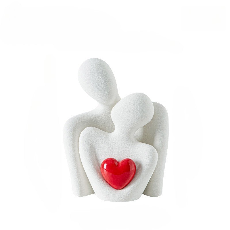 Baltos spalvos abstrakti skulptūra su raudonu širdies akcentu.