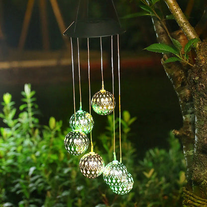 Saulės vėjo varpeliai su LED rutuliais – balti rutuliai medyje