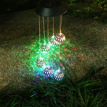 Saulės vėjo varpeliai su LED rutuliais – spalvoti rutuliai šviečia ant žolės