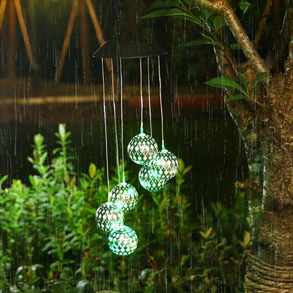 Saulės vėjo varpeliai su LED rutuliais – žalsvai balti rutuliai medyje