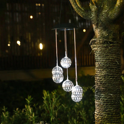 Saulės vėjo varpeliai su LED rutuliais – balti rutuliai tamsiame fone