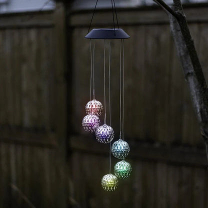 Saulės vėjo varpeliai su LED rutuliais – balti rutuliai ant tvoros